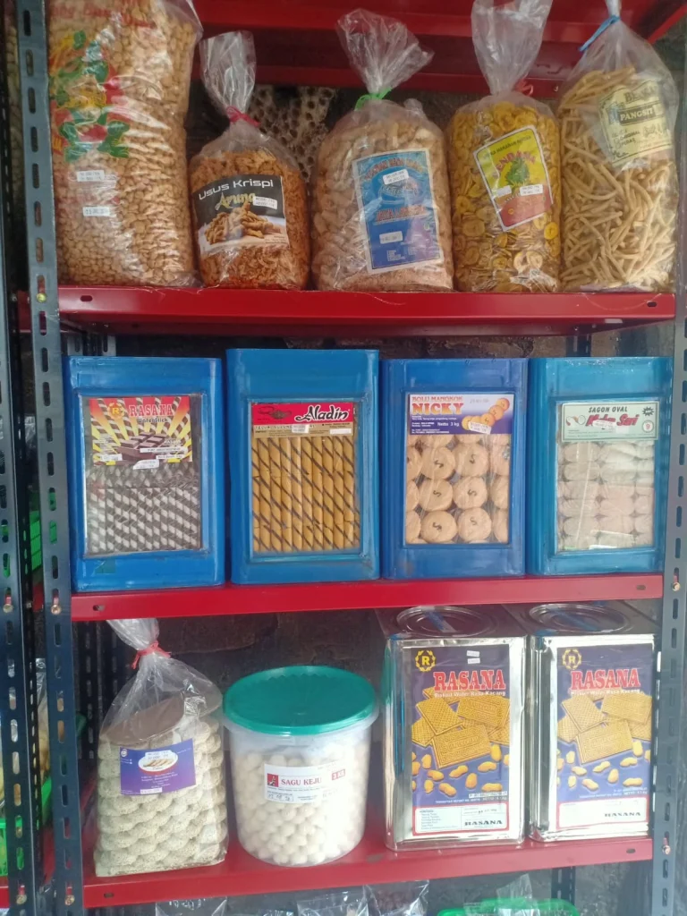 Etalase Hasanah Snack berisi aneka camilan tradisional seperti keripik, usus krispi, pisang sale, kue kering, hingga sagu keju dalam kemasan plastik dan kaleng.