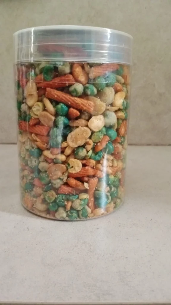 Kacang campur Hasanah Snack dalam toples plastik bening, camilan khas Bandung yang gurih dan renyah.